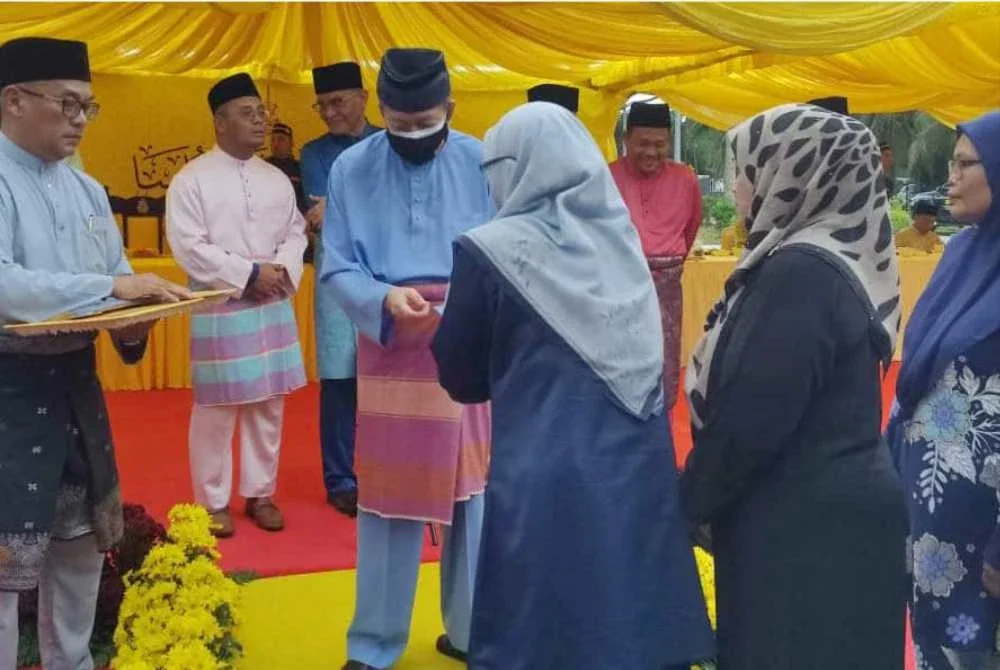 Sultan Selangor menyampaikan sumbangan kepada salah seorang penerima pada Majlis Berbuka Puasa bersama Rakyat dan Sumbangan Hari Raya Aidilfitri di Masjid Jamek Sultan Ibrahim pada Selasa.
