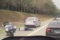 Tangkap layar video tular menunjukkan seorang anggota polis trafik dan mangsa terbaring atas jalan raya selepas kemalangan di Lebuhraya Utara Selatan, Tangkak.