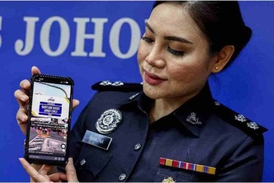 Media Ibu Pejabat Polis Kontinjen Johor, Inspektor Ramona Roslan, menunjukkan antara akaun penipuan promosi Bantuan Kasih Johor di TikTok pada sidang media berhubung sindiket scam AI yang meniru wajah dan suara Exco Johor bagi mempromosikan bantuan tersebut, di Ibu Pejabat Polis Kontinjen Johor, pada Selasa. Foto Bernama
