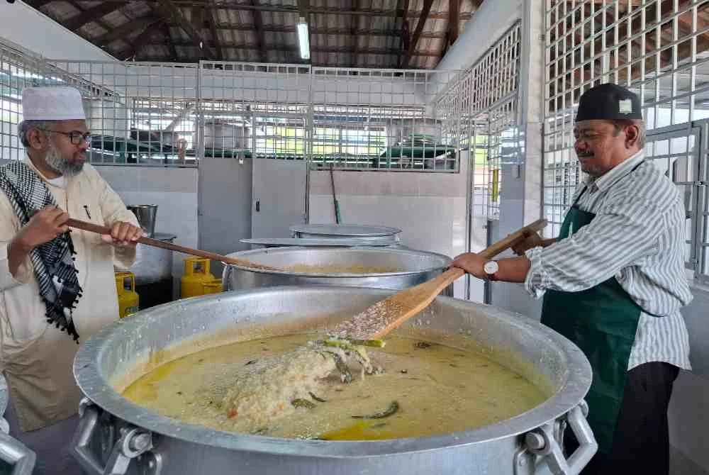 Shaik Mujibur Rahman (kanan) bersama Imam Masjid, Muhamad Abbas Hafiz Muhamad Ali turut turun ke dapur memastikan bubur lambuk siap dimasak untuk diedarkan.
