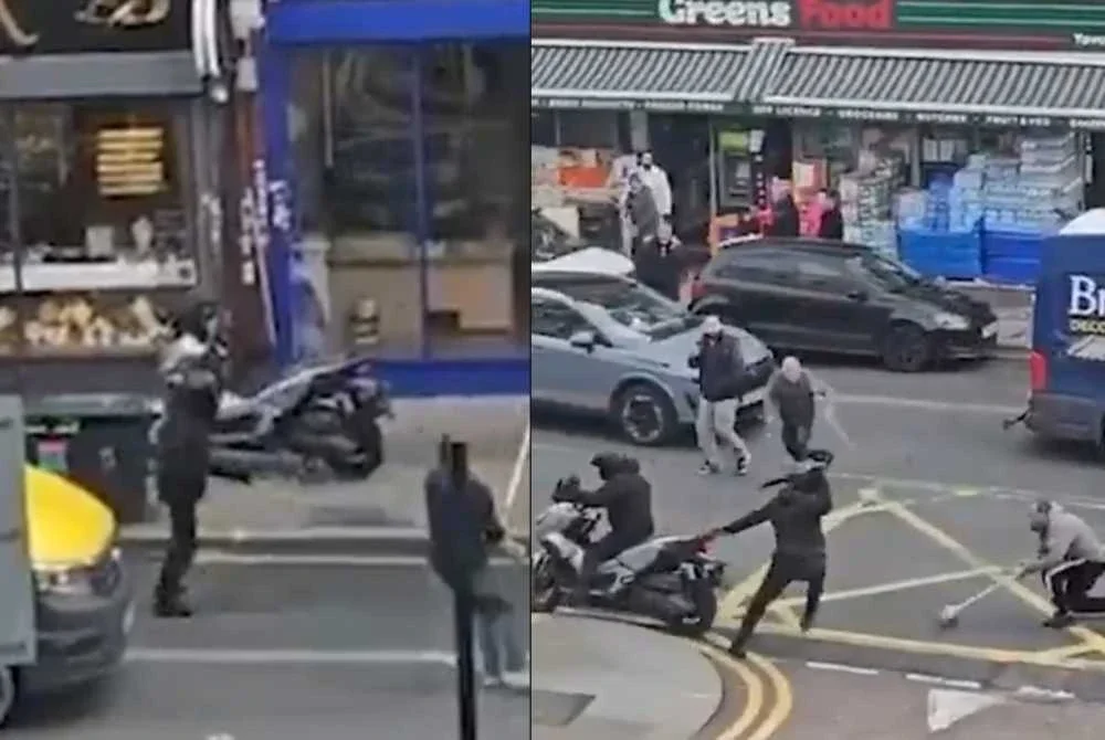 Salah seorang menggunakan penyapu berus panjang untuk menghalang suspek. - Agensi