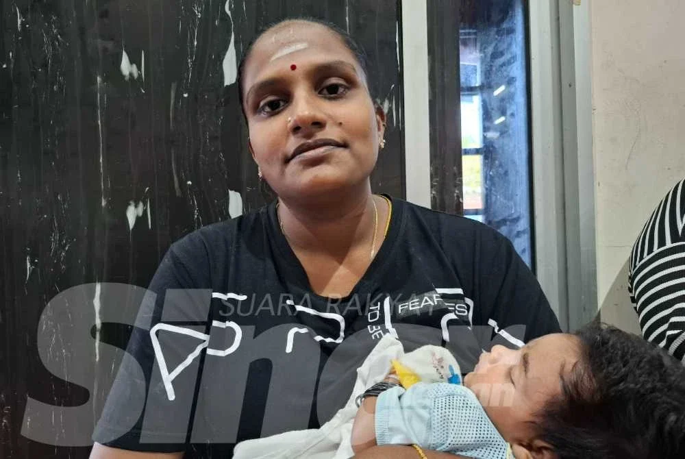 Kanageswary mengendong bayi kecilnya ketika ditemui di PPS Dewan Serbaguna Taman Kaya pada Rabu.