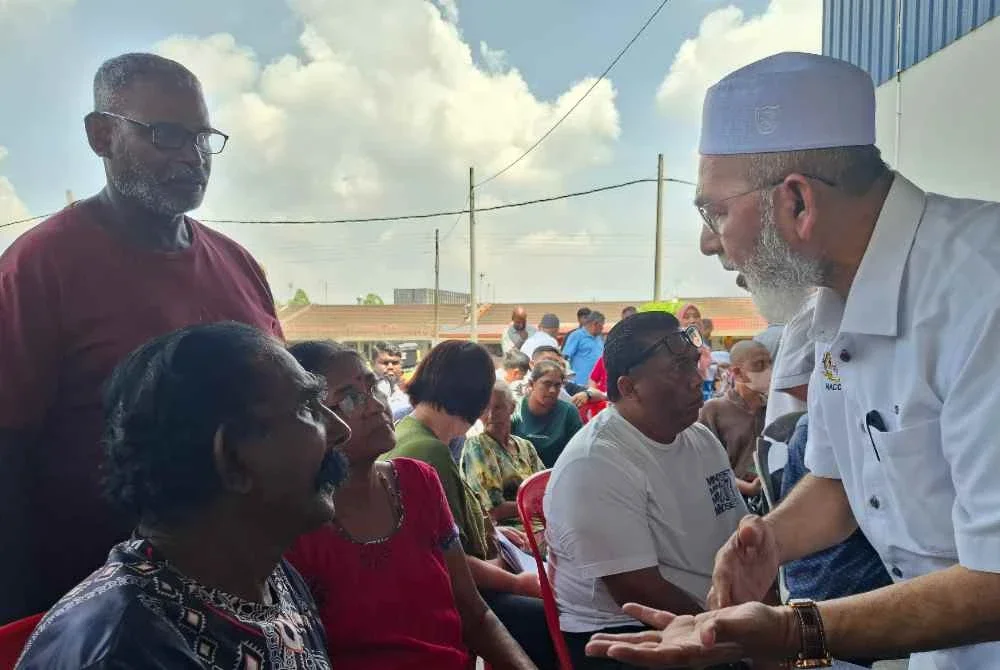Syed Abu Hussin menyantuni mangsa ribut ketika meninjau PPS Dewan Serbaguna Taman Kaya dekat Taiping pada Rabu.