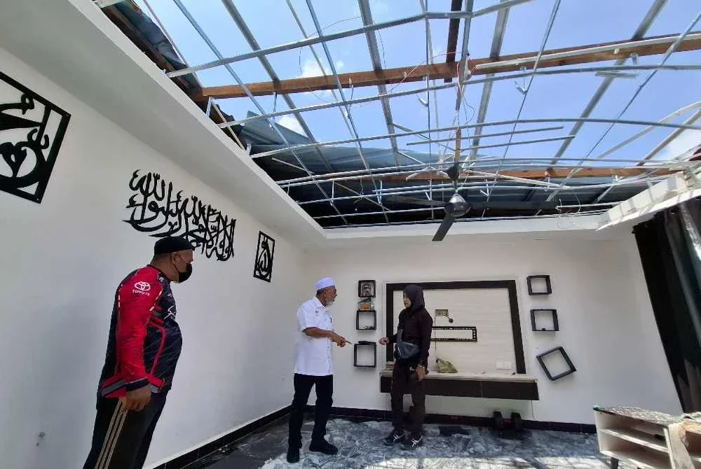 Syed Abu Hussin (tengah) meninjau keadaan rumah penduduk yang terjejas teruk akibat kejadian ribut yang melanda beberapa kawasan perumahan di Bukit Gantang.