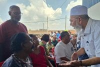 Syed Abu Hussin menyantuni mangsa ribut ketika meninjau PPS Dewan Serbaguna Taman Kaya dekat Taiping pada Rabu.