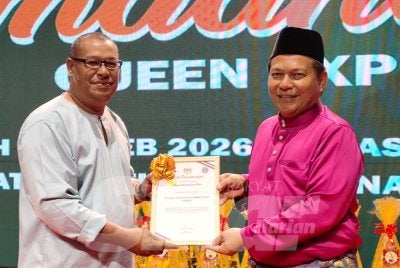 Mohd Suffian (kanan) menerima pengiktirafan Sijil Tempat Kerja Bebas Dadah (TEKAD) yang disampaikan oleh Ketua AADK Kota Bharu, Muhammad kepada Queen Express di Kota Bharu pada Selasa malam. Foto HAZELEN LIANA KAMARUDIN