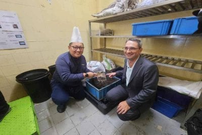 Thor (kanan) menunjukkan hasil sisa bufet yang diproses menjadi kompos dan dihantar kepada petani di Kundasang.