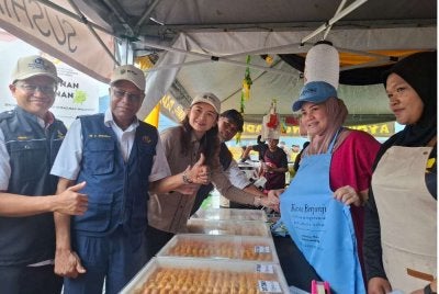 Dr Feisul Idzwan (kiri) bersama Sivanesan (dua dari kiri) menyerahkan apron kepada peniaga Bazar Ramadan Bandar Baru Kampar sempena Pelancaran Operasi Keselamatan Makanan bulan Ramadan peringkat negeri Perak 2026 dan Kempen ‘Back to Bekas’ pada Selasa.