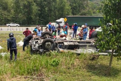 Orang ramai cuba membantu pemandu lori dan kelindan yang terlibat dalam kemalangan di Persiaran Mokhtar Dahari pada Rabu. 