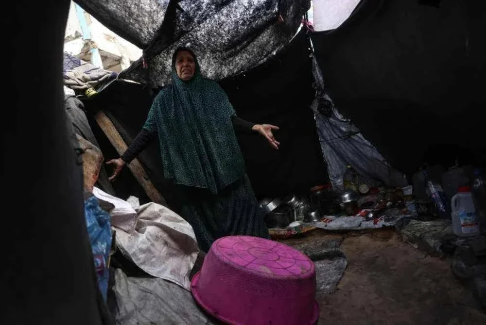 Seorang wanita Palestin tidak mampu menahan sebak melihat khemah sementaranya yang bocor dan rosak.