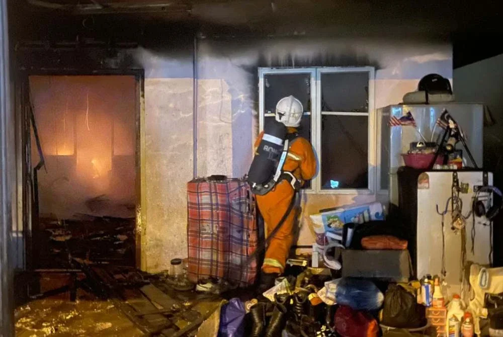 Anggota bomba menjalankan kerja-kerja pemadaman di sebuah rumah yang terbakar di Jalan Lahat, Simpang Pulai yang mengorbankan seorang warga emas pada Rabu. Foto: JBPM Perak