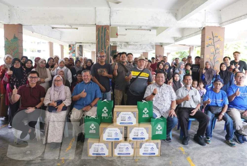Firdaus (duduk, dua dari kiri) bersama Nik Justin (duduk, empat dari kanan) bergambar bersama penerima sumbangan al-Quran dan produk Nestle sempena program CSR 2026 Karangkraf x Nestle Ramadan Food Drive di Pangsapuri Teratai Taman Bukit Subang, Shah Alam pada Khamis
