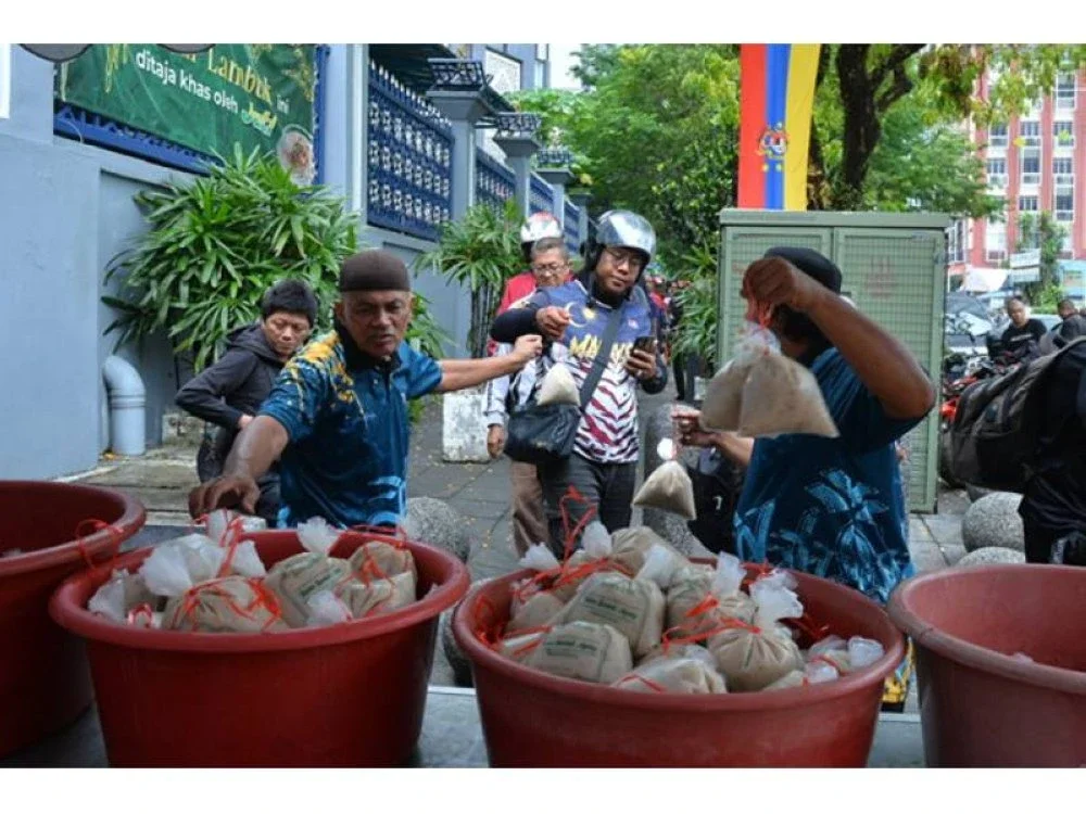 Ahli jawatankuasa mengagihkan bubur lambuk di Masjid Jamek Kampong Bharu, Kuala Lumpur.