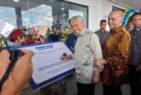 Ahmad Zahid menandatangani plak perasmian Mydin Mart Bagan Datuk sempena pembukaan pada Jumaat. Turut kelihatan, Pengarah Urusan Mydin, Datuk Ameer Ali Mydin.