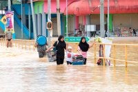 Penduduk sekitar Pekan Beaufort mengharungi banjir keluar dari pekan itu berikutan hujan lebat di daerah ini tiga hari lepas. - Foto: Bernama
