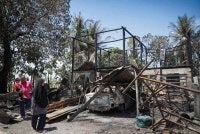 Hasnul Hadi bersama isteri Siti Hajar melihat rumah mereka di Kampung Sungai Padang, Simpang Empat yang musnah dalam kebakaran pada Khamis. FOTO: Bernama 