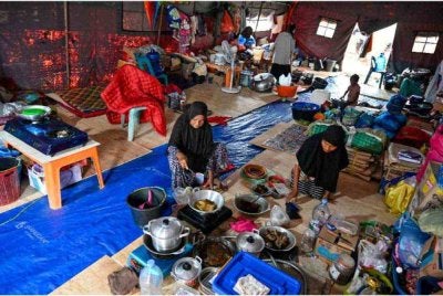 Penduduk pusat perlindungan memasak juadah berbuka puasa Ramadan di dalam khemah yang menempatkan mangsa banjir di Meurah Dua, daerah Pidie Jaya.- AFP
