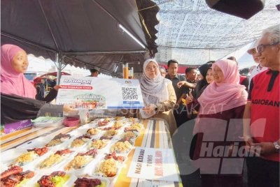 Fuziah (tiga dari kanan) menyampaikan replika kad diskaun khas kepada peniaga semasa mengadakan sesi Walkabout Bazar Ramadan Rahmah (BRR) Peringkat Zon Timur di pekarangan Mydin Mall Tunjung, Kota Bharu pada Jumaat. - Foto:SINAR HARIAN/HAZELEN LIANA KAMARUDIN