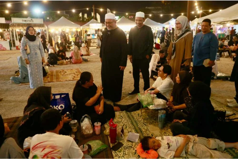 Wan Sukairi (tengah) beramah mesra bersama pengunjung Program Selepek Sahur di tapak Payang Walk, Dataran Shah Bandar, Kuala Terengganu pada Jumaat.