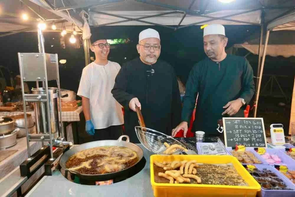 Wan Sukairi (tengah) menyempurnakan perasmian Program Selepek Sahur di tapak Payang Walk, Dataran Shah Bandar, di Kuala Terengganu. 