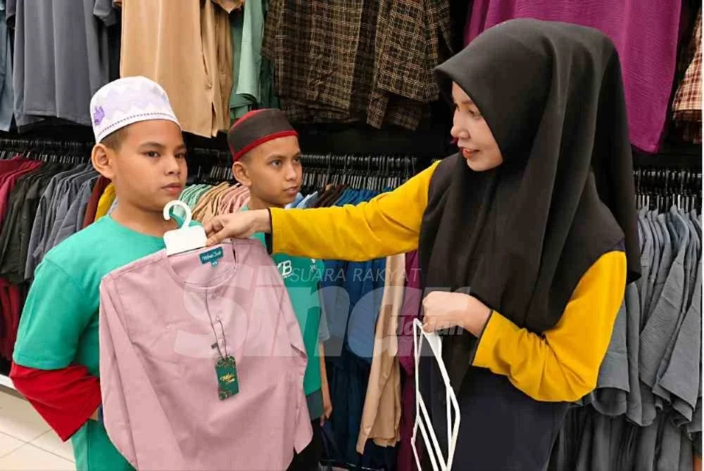 Taufiq (kanan) dan Naufal memilih sendiri baju raya kegemaran mereka selain menikmati dapat suasana membeli-belah kelengkapan hari raya bersama rakan-rakan yang lain. Foto:SINAR HARIAN/HAZELEN LIANA KAMARUDIN
