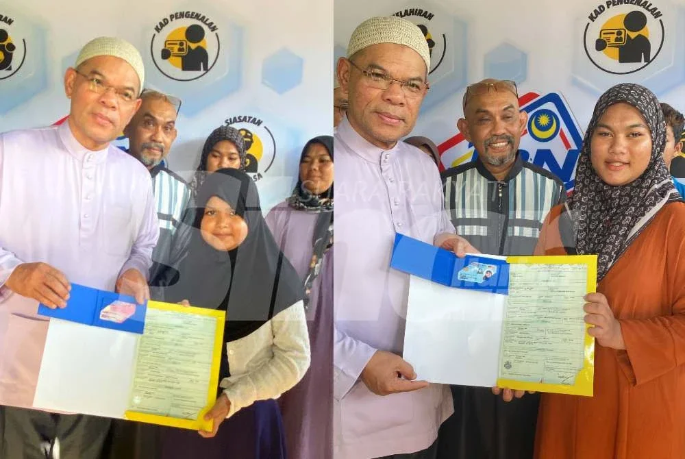 Saifuddin Nasution menyampaikan MyKad kepada penerima pada Program MEKAR JPN di Kampung Kampung Simpol Belubang, Machang pada Sabtu. Foto: HAZELEN LIANA KAMARUDIN