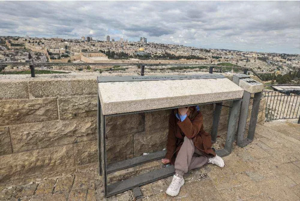 Seorang individu berlindung ketika siren amaran berbunyi di Baitulmaqdis pada 28 Februari 2026, susulan pengumuman bahawa Israel melancarkan “serangan pencegahan awal” terhadap Iran. Foto: AFP