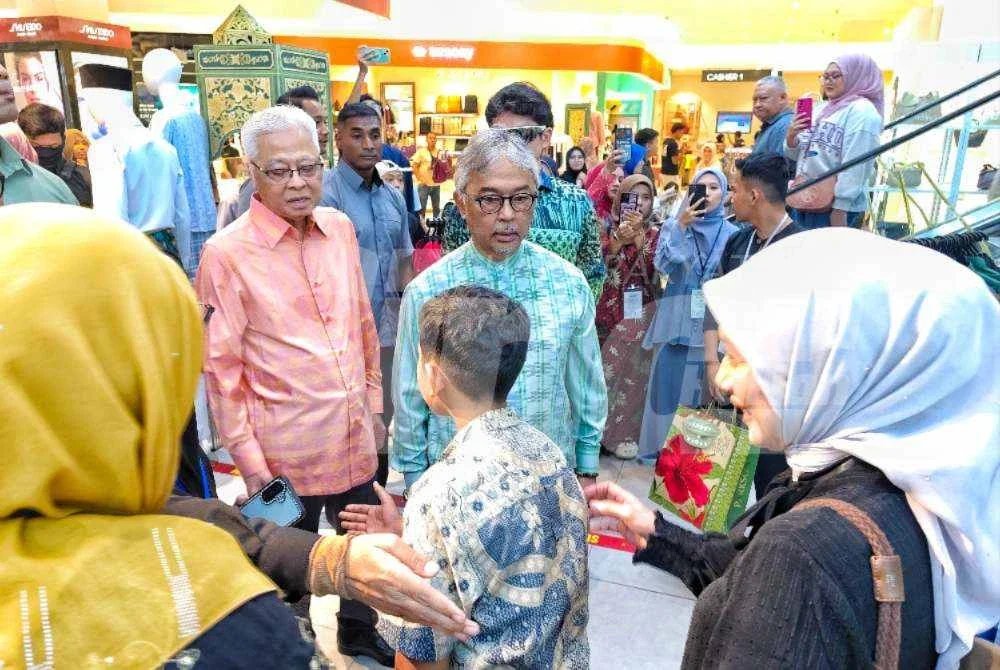 Ismail Sabri (dua dari kiri) mengiringi Al-Sultan Abdullah (tengah) bertemu dengan penerima yang memilih pakaian untuk hari raya.