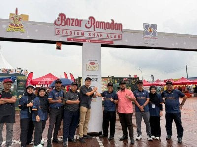 Rusman (lima, kanan) bersama wakil penaja Rasaku dan pegawai DEFM di hadapan pintu gerbang Bazar Ramadan Stadium Shah Alam yang alami perubahan lebih sistematik.