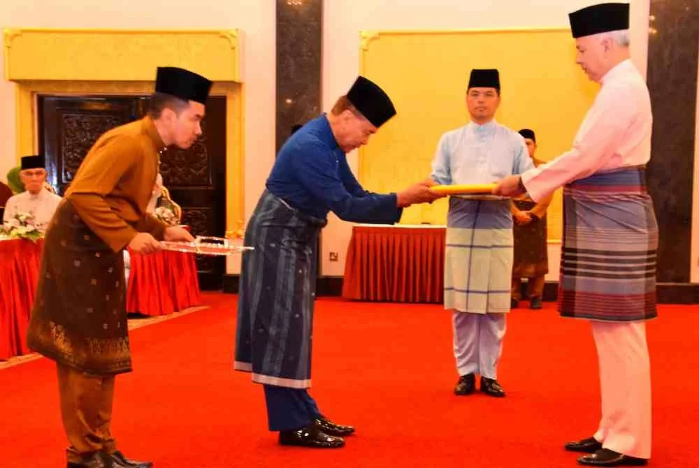 Sultan Nazrin (kanan) menyerahkan zakat kepada Mohd Annuar sempena Majlis Penyerahan Zakat dan Berbuka Puasa di Istana Iskandariah, Bukit Chandan pada Sabtu.