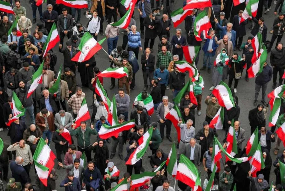 Penunjuk perasaan berkumpul sambil membawa bendera kebangsaan Iran semasa satu demonstrasi bagi menyokong kerajaan dan membantah serangan AS serta Israel di luar sebuah masjid di Tehran pada 28 Februari 2026. Foto AFP