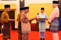 Syed Abu Hussin (tengah) menyerahkan zakat perniagaan berjumlah RM2.3 juta di hadapan Sultan Nazrin sempena Majlis Penyerahan Zakat dan Berbuka Puasa yang disempurnakan oleh di Istana Iskandariah, Bukit Chandan pada Sabtu.