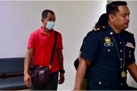 Hasdi (kiri) ketika dihadapkan di Mahkamah Sesyen di Kuala Terengganu pada Ahad.