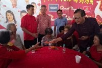 Dominic (kanan) menyantuni warga emas yang hadir dengan pemberian angpau sempena Majlis Perayaan Tahun Baharu Cina 2026 di Pusat Parti Gerakan Ipoh, Kampung Simee pada Ahad.