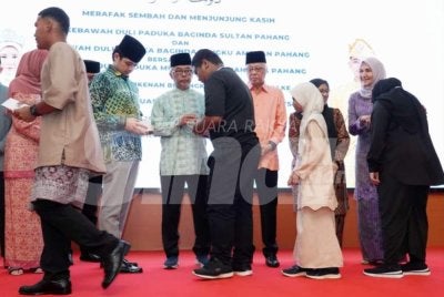 Ismail Sabri (tiga dari kanan) mengiringi Al-Sultan Abdullah dan Tengku Hassanal menyerahkan sampul raya kepada penerima Majlis Berbuka Puasa YKM di Hotel Grand Darul Makmur pada Sabtu.