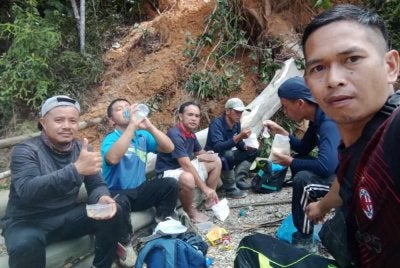 Jeffrey (kanan), Tony (kiri) dan Yahudi (dua dari kiri) bersama tiga lagi rakan sekampung meredah perjalanan tanah runtuh dengan berjalan kaki selama tujuh jam keluar dari Kampung Sumambu, Tenom, untuk mendapatkan bekalan makanan.