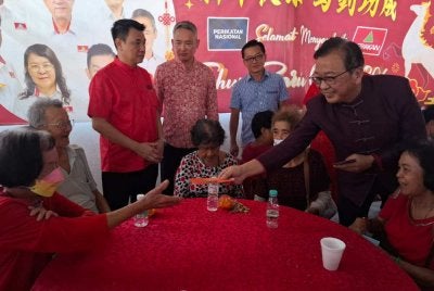 Dominic (kanan) menyantuni warga emas yang hadir dengan pemberian angpau sempena Majlis Perayaan Tahun Baharu Cina 2026 di Pusat Parti Gerakan Ipoh, Kampung Simee pada Ahad.