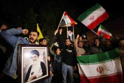 Penunjuk perasaan di Iraq turut membawa potret Ali Khamenei sambil melaungkan slogan mengutuk kekejaman AS dan Israel serta mengibarkan bendera Iran ketika berarak menuju ke Zon Hijau di ibu kota. - Foto AFP