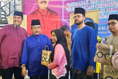 Johari (dua dari kiri) menyampaikan sumbangan cermin mata kepada belia sekolah.