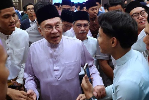 Anwar (tengah) beramah mesra bersama para pelajar pada Majlis Berbuka Puasa Kementerian Pendidikan dan Kementerian Pendidikan Tinggi di Kompleks Seri Perdana pada Sabtu. Foto: Bernama
