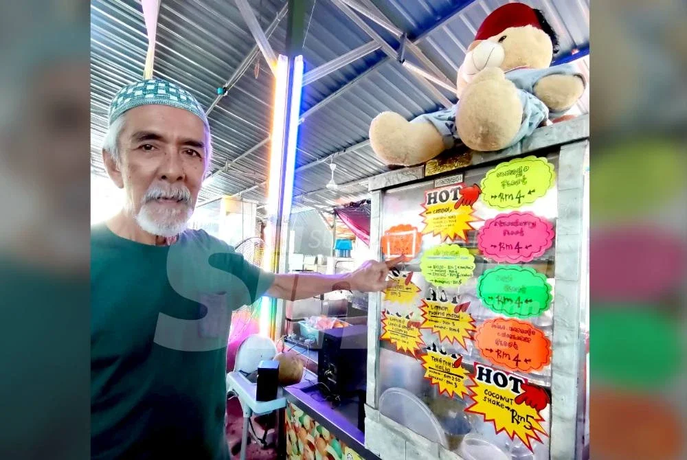 Syed Akir menunjukkan menu minuman beserta harga di gerainya, SS Tarbuih.