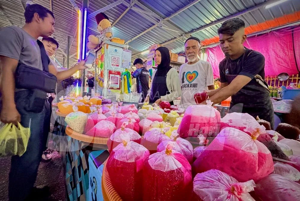 Syed Akir (dua dari kanan) dan anak serta cucunya sedang melayan pelanggan yang datang ke gerainya.