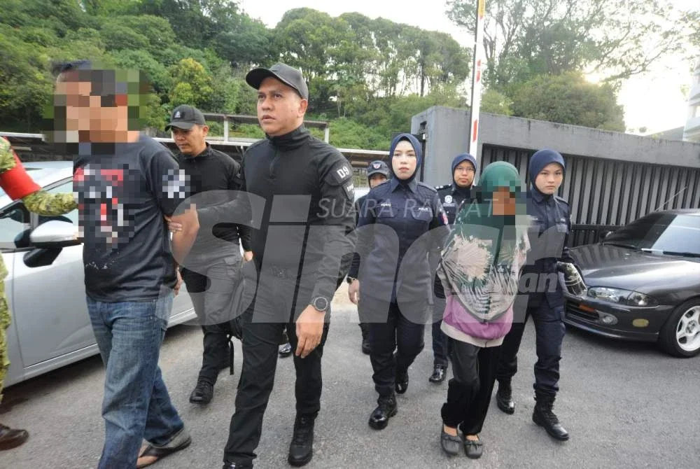 Tertuduh (kiri) dibawa ke Mahkamah Sesyen Johor Bahru pada Isnin.