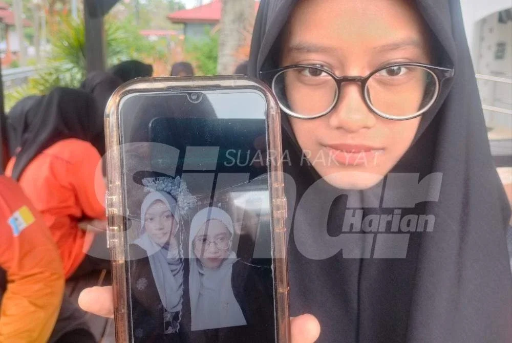 Putri Aisya Humaira menunjukkan gambar kenangan bersama arwah Siti Nur Zulaikha.