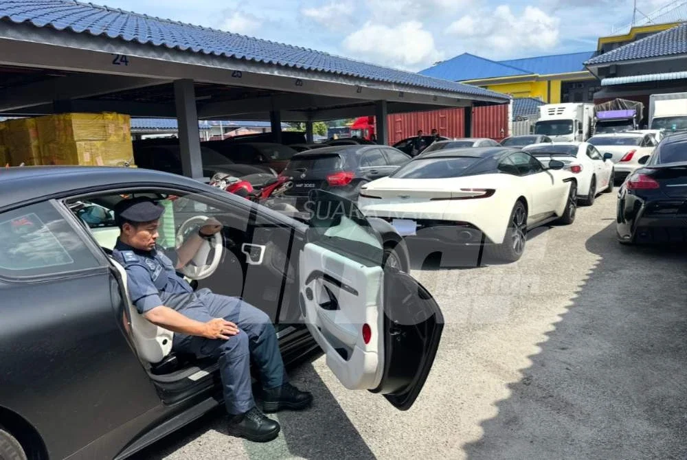 Ishak melihat ke dalam kereta yang dirampas kastam. Foto: ADILA SHARINNI WAHID