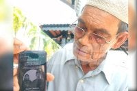 Hashim menunjukkan gambar dua cucu yang maut dalam kemalangan pada Ahad.