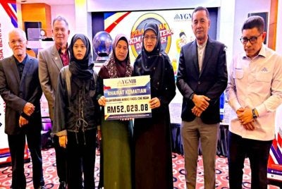 Norfadzliana (tiga dari kiri) dan ibunya, Asiah menerima sumbangan khairat kematian yang disampaikan oleh Siti Norina (tiga dari kanan) pada Pelancaran Skim Sejahtera dan Skim Kasih Warga Pendidik YGMB di Kota Bharu pada Isnin.