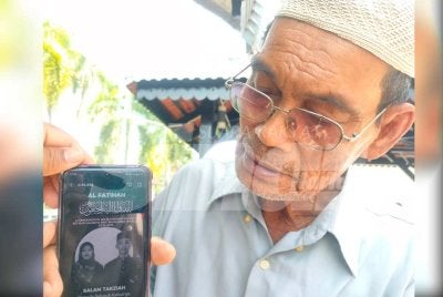 Hashim menunjukkan gambar dua cucu yang maut dalam kemalangan pada Ahad.