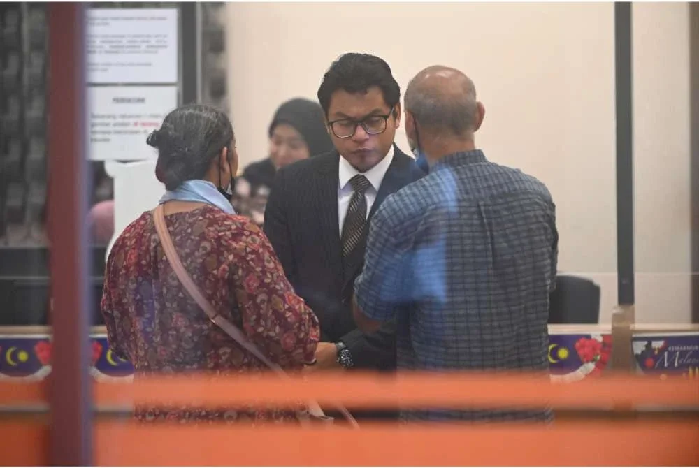 K Selvanathan (kanan) bersama Muhammad Amirul Afiqq berbincang selepas selesai prosiding pertuduhan kes anaknya di Mahkamah Kuantan pada Selasa.
