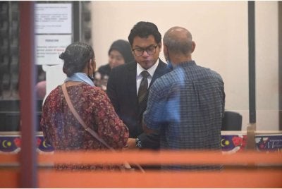 K Selvanathan (kanan) bersama Muhammad Amirul Afiqq berbincang selepas selesai prosiding pertuduhan kes anaknya di Mahkamah Kuantan pada Selasa.